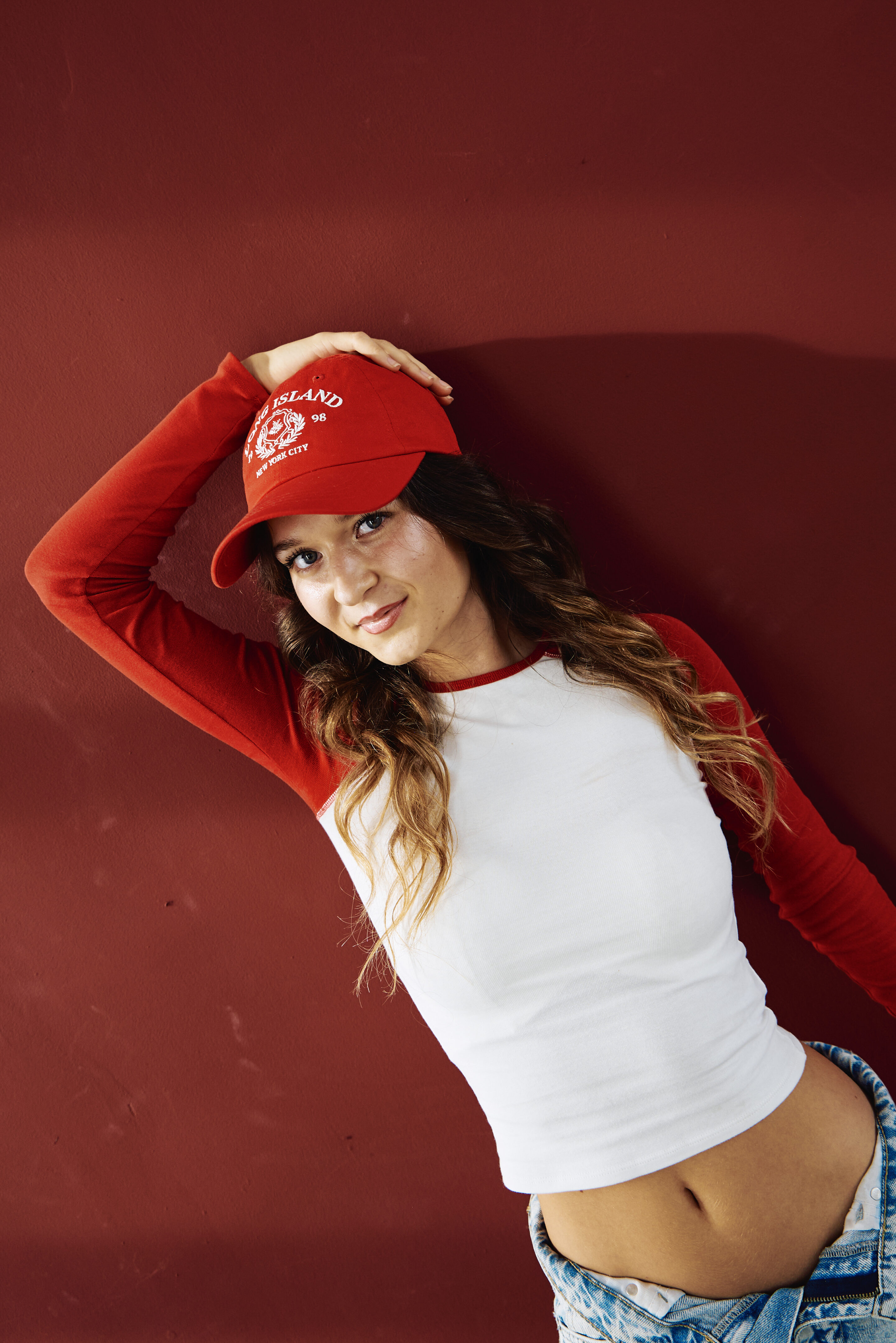 Portrait mit roter Kappe vor roter Wand